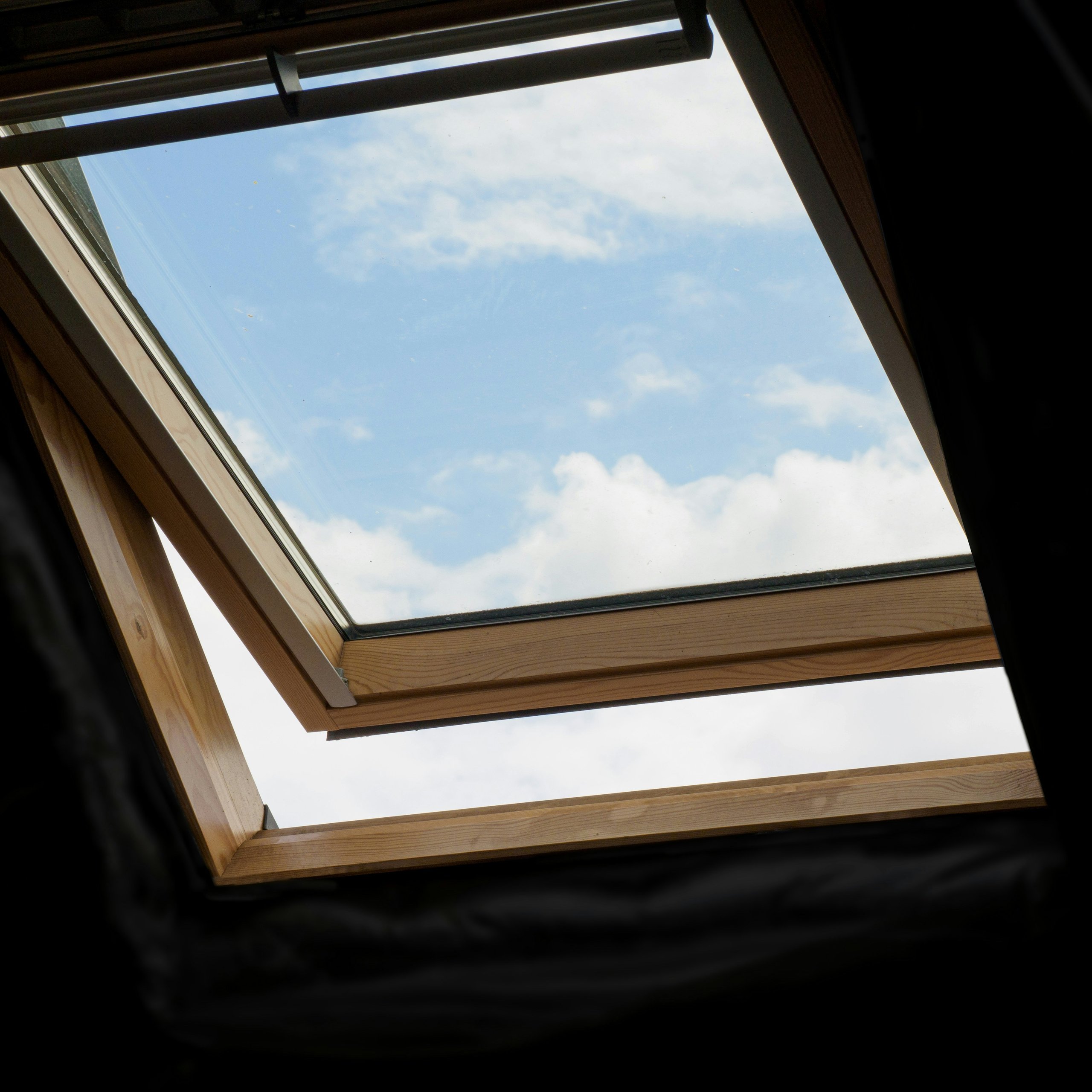 Holz-Dachfenster, geöffnet gegen blauen Himmel
