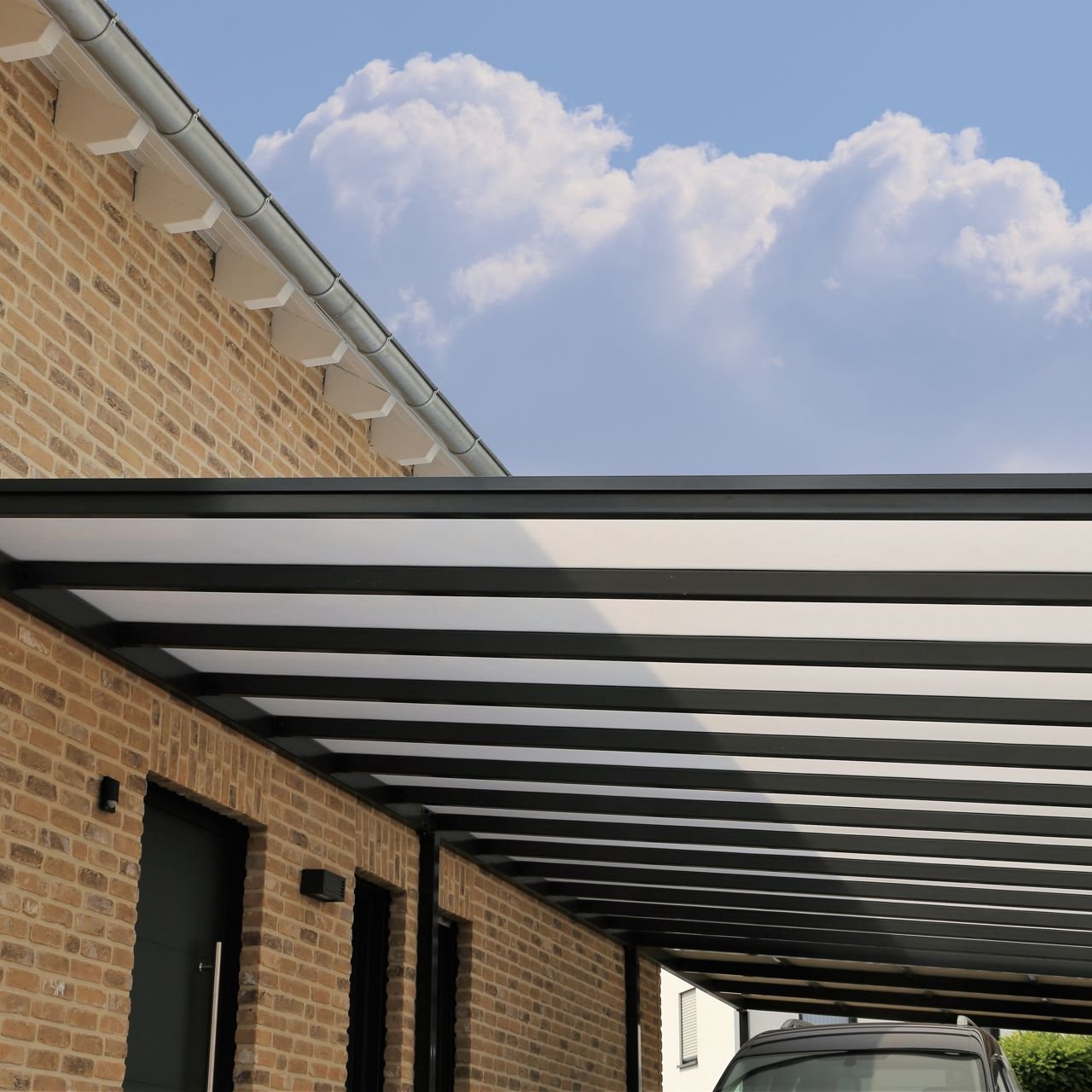 Moderner Carport-Vorbau aus Glas und Metall
