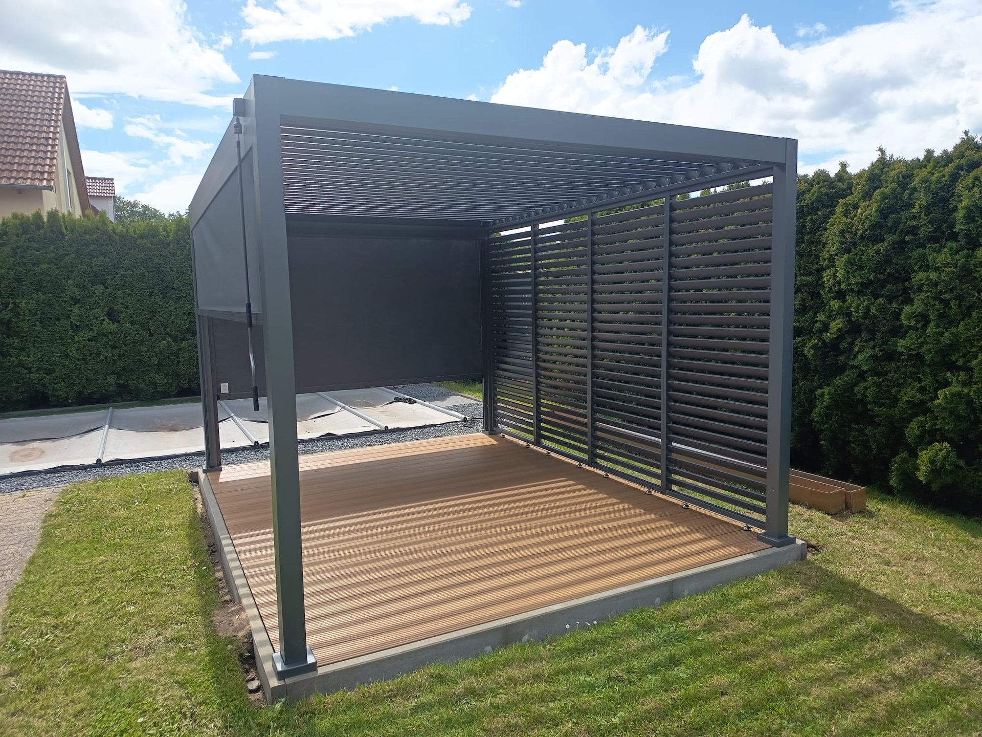 Begrünter Gartenpavillon mit Holzterrasse und Lamellendach